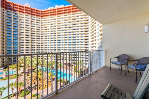 a balcony with chairs and a view of a building at Shores of Panama 727 - Same level parking space! in Panama City Beach
