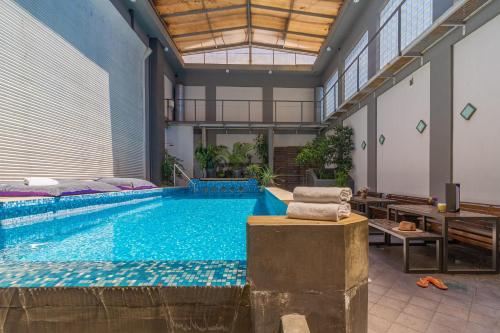 a large swimming pool in a large room with a large ceiling at Prodeo Hotel + Lounge in Buenos Aires