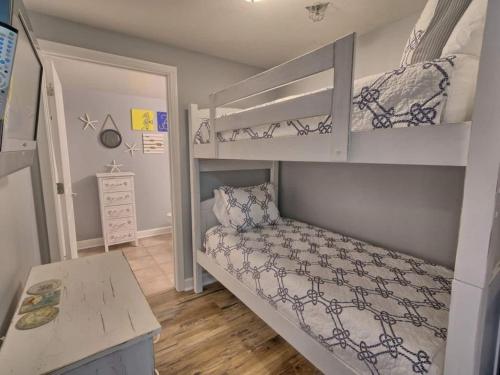 a small bedroom with a bunk bed and a desk at Shores of Panama 1307, Two Masters! Under 25 ok! in Panama City Beach