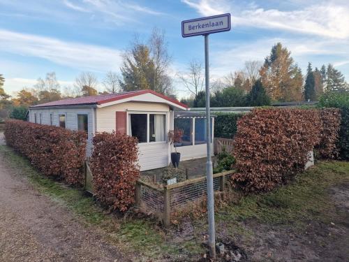 a street sign in front of a small house at Chalet De Zilverberk Veluwe 4pers in Beekbergen
