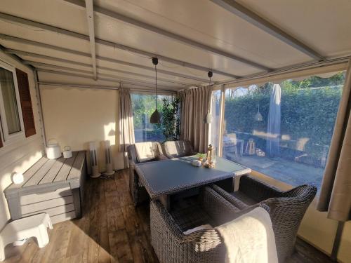 a living room with a table and chairs and a couch at Chalet De Zilverberk Veluwe 4pers in Beekbergen