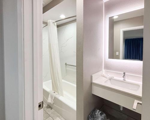 a bathroom with a sink and a bath tub at Studio 6 Sulphur LA in Sulphur