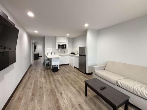 a living room with a couch and a kitchen at Studio 6 Sulphur LA in Sulphur