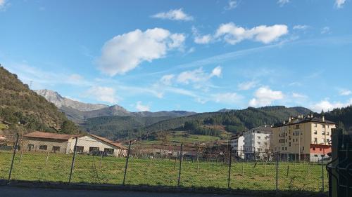 a fence in a field with mountains in the background at Apartamento Peñalabra in Potes
