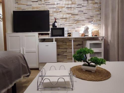 un soggiorno con TV e tavolo con due alberi di La Romana a Santiponce