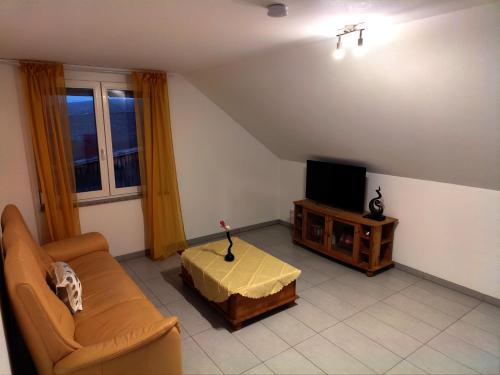 a living room with a couch and a tv at Serene work/holiday apartment in Renningen