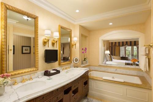 a bathroom with a tub and a large mirror at Fairmont Grand Del Mar in San Diego