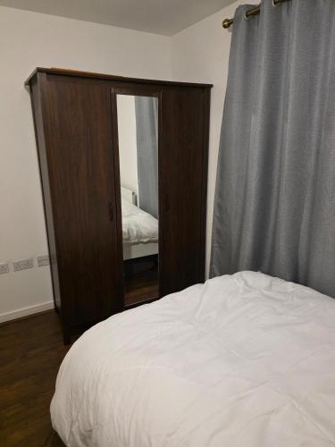 a bedroom with a dresser with a mirror and a bed at Glory Home 1 in Dartford