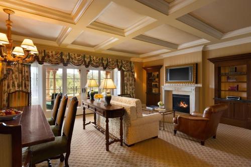 a living room with a dining table and a fireplace at Fairmont Grand Del Mar in San Diego
