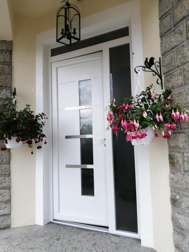 a white door with two potted plants on it at Esprit de famille in Saint-Agnan-sur-Loire