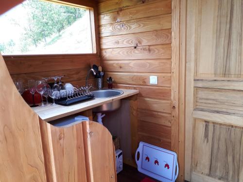 a kitchen with a sink in a wooden cabin at la ronde des banons in Thoard