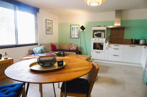 un salon avec une table et une cuisine dans l'établissement Lo' Ruino - Clim - 4 Pers - Plage - Prest 'immo, à Leucate-Plage
