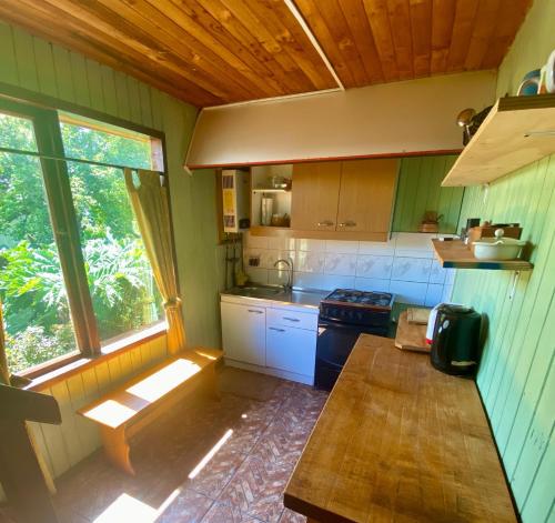 a kitchen with a table and a stove in it at Cabaña en Contao Carretera Austral Hualaihué in Contao