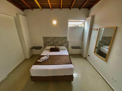 a bedroom with two beds and a mirror at Hotel Buenos Aires Central in Medellín