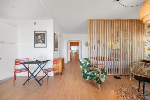 un salon avec une table et des chaises dans l'établissement Les Orangers, Charmant studio avec coin nuit, incroyable vue sur la ville et la mer, parking, à Menton