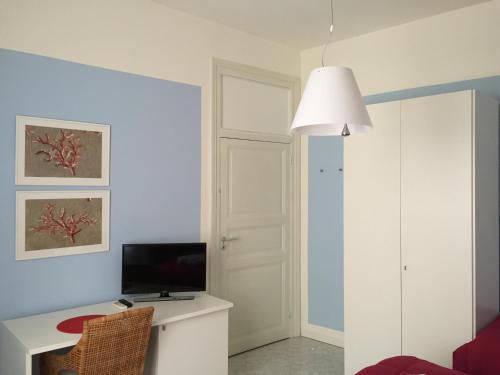a room with a desk with a television and a lamp at AlbaChiara Suite Rooms - City Center in Trapani