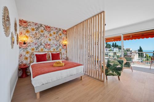 une chambre avec un lit et un balcon dans l'établissement Les Orangers, Charmant studio avec coin nuit, incroyable vue sur la ville et la mer, parking, à Menton