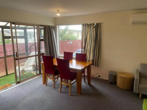 a dining room with a wooden table and chairs at Cosy 2 bedroom home in Miramar in Wellington