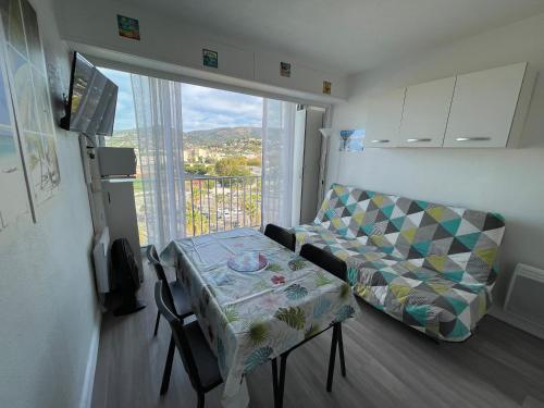 un salon avec un canapé, une table et une fenêtre dans l'établissement Horizon 5 pied dans l'eau, au Lavandou