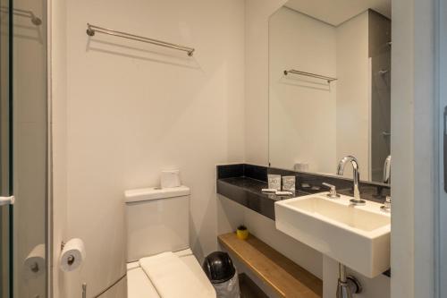 a bathroom with a white toilet and a sink at 360 VN Turiassú by Housi in Sao Paulo