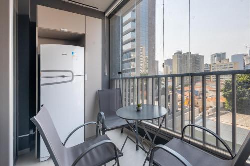 a balcony with a refrigerator and a table and chairs at 360 VN Turiassú by Housi in Sao Paulo