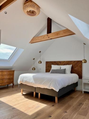 - une chambre avec un grand lit et une lucarne dans l'établissement Grande maison avec jacuzzi couvert, à Riec-sur-Bélon