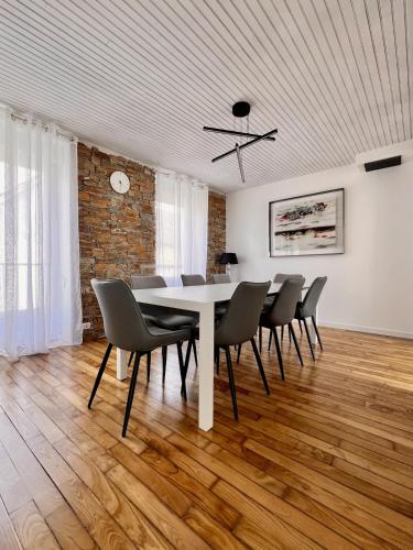 une salle à manger avec une table et des chaises blanches dans l'établissement Grande maison avec jacuzzi couvert, à Riec-sur-Bélon