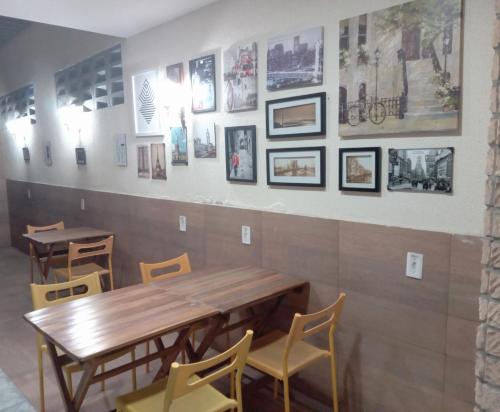 a restaurant with tables and chairs and pictures on the wall at Hostel Aldeia Inn in Fortaleza