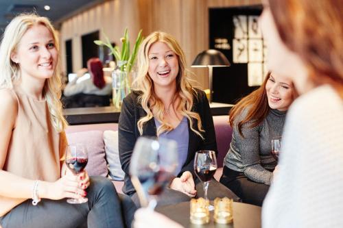 a group of women sitting around a table with wine glasses at Vox Hotel in Jönköping
