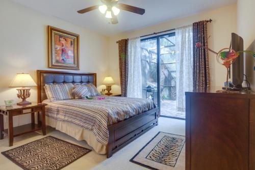 Un dormitorio con una cama y un televisor y una ventana. en Upscale Marco Island Villa with Outdoor Bar and Pool!, en Marco Island