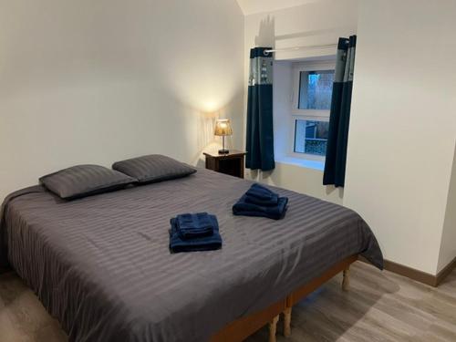 une chambre avec un lit avec deux serviettes bleues dessus dans l'établissement Chez JP, à Saint-Côme-de-Fresné