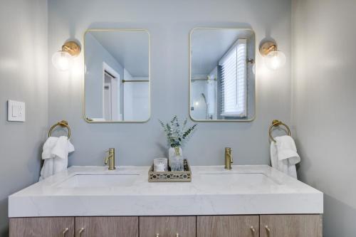 baño con lavabo blanco y 2 espejos en Cabin in the Woods, en Wagners Forest Park