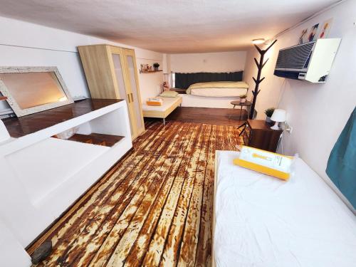 a small room with a wooden floor and a bedroom at La Guardia on the boulevard in Tel Aviv
