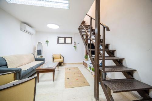 a living room with a staircase and a couch at La Guardia on the boulevard in Tel Aviv