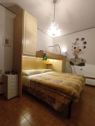 a bedroom with a bed and a dresser in it at La Jolie in Pisa