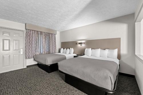 a hotel room with two beds and a window at Quality Inn & Suites at Dollywood Lane in Pigeon Forge