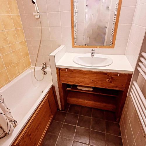 une salle de bain avec un lavabo, une baignoire et un miroir dans l'établissement le petit chambourguet, à Besse-et-Saint-Anastaise
