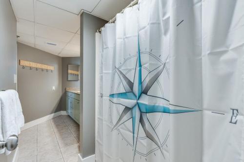 een badkamer met een douche met een douchegordijn bij Sunbird 407E - Pearl Gulf Getaway - Sleeps 4 in Panama City Beach