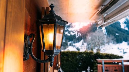 a lamp on the side of a building with a window at Chalet Panorama - Stunning View in Grindelwald