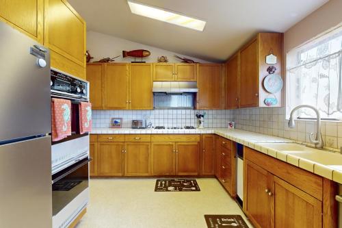 a kitchen with wooden cabinets and a sink at Pinnacle Heights in Bodega Bay