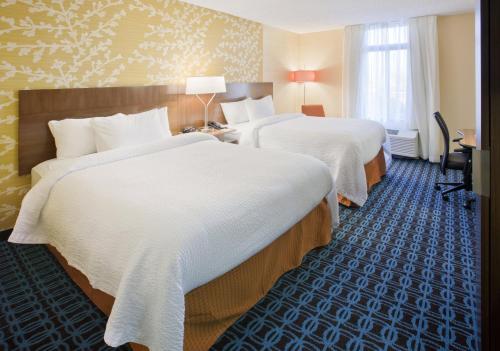 a hotel room with two beds with white sheets at Fairfield Inn by Marriott East Rutherford Meadowlands in East Rutherford