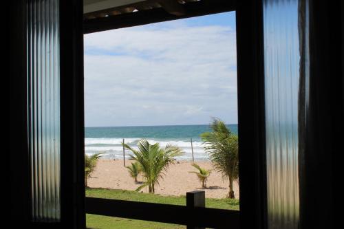 a view of the beach from a window at Pousada Pé na areia in Camaçari