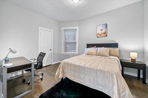 a white bedroom with a bed and a desk at Cozy Woodlawn Retreat 1 in Chicago