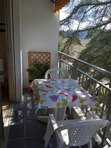 une table et deux chaises sur un balcon dans l'établissement Détente curiste, à Gréoux-les-Bains