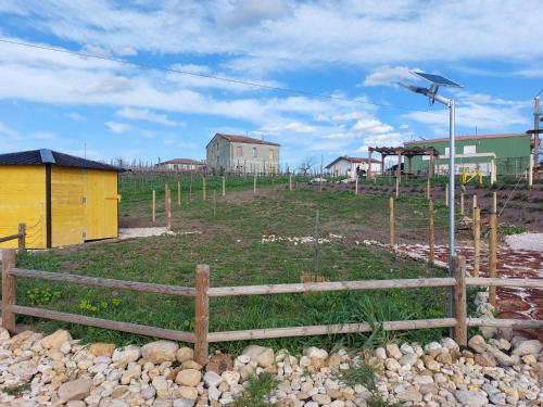 a field with a fence and a building and a house at Il poggio degli antichi sapori in Paternopoli