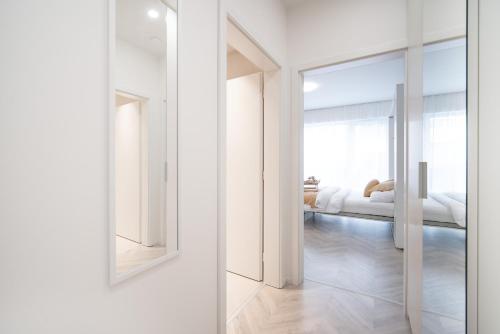 a white room with a bed and a mirror at apartino - FREE parking, 10 minutes walk to city centre, nespresso, netflix in Brno