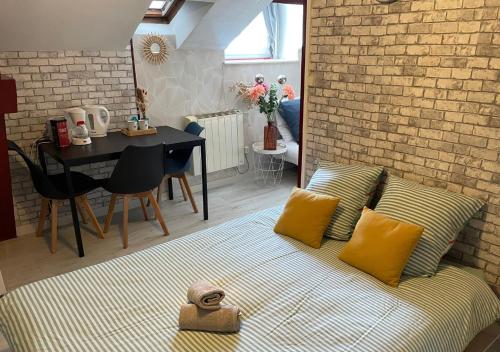 Cette chambre comprend un lit avec des oreillers jaunes et une table. dans l'établissement Cosy au pied de la gare de Dijon, à Dijon