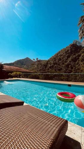 a swimming pool with two frisbees in the water at Eco Hostel y Cabañas Duck House in La Vega