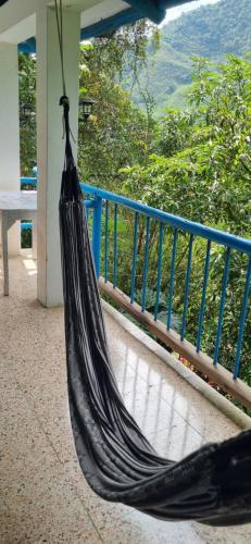a hammock on a porch with a view of the mountains at Eco Hostel y Cabañas Duck House in La Vega