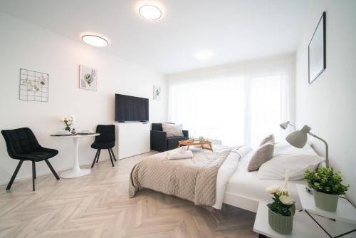 a white bedroom with a bed and a desk at apartino - FREE parking, 10 minutes walk to city centre, nespresso, netflix in Brno